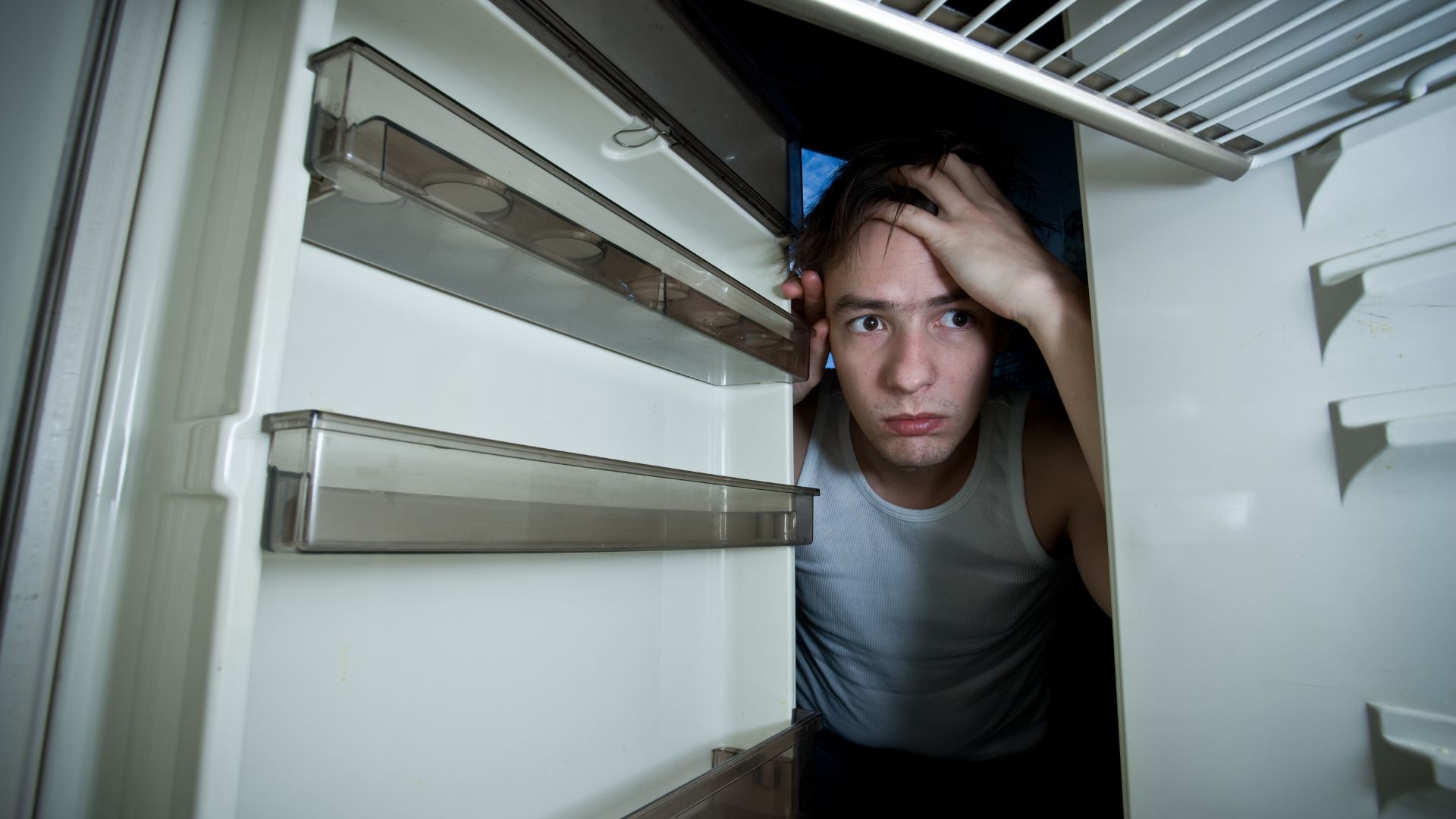 A man looking into his fridge. Refrigerator Freezing Food